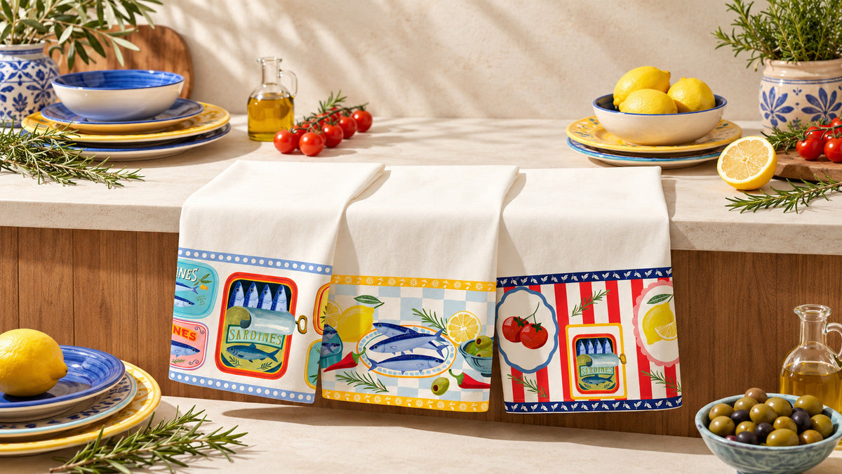 Três panos de prato brancos com estampas coloridas em cozinha com pratos, limões e tomates